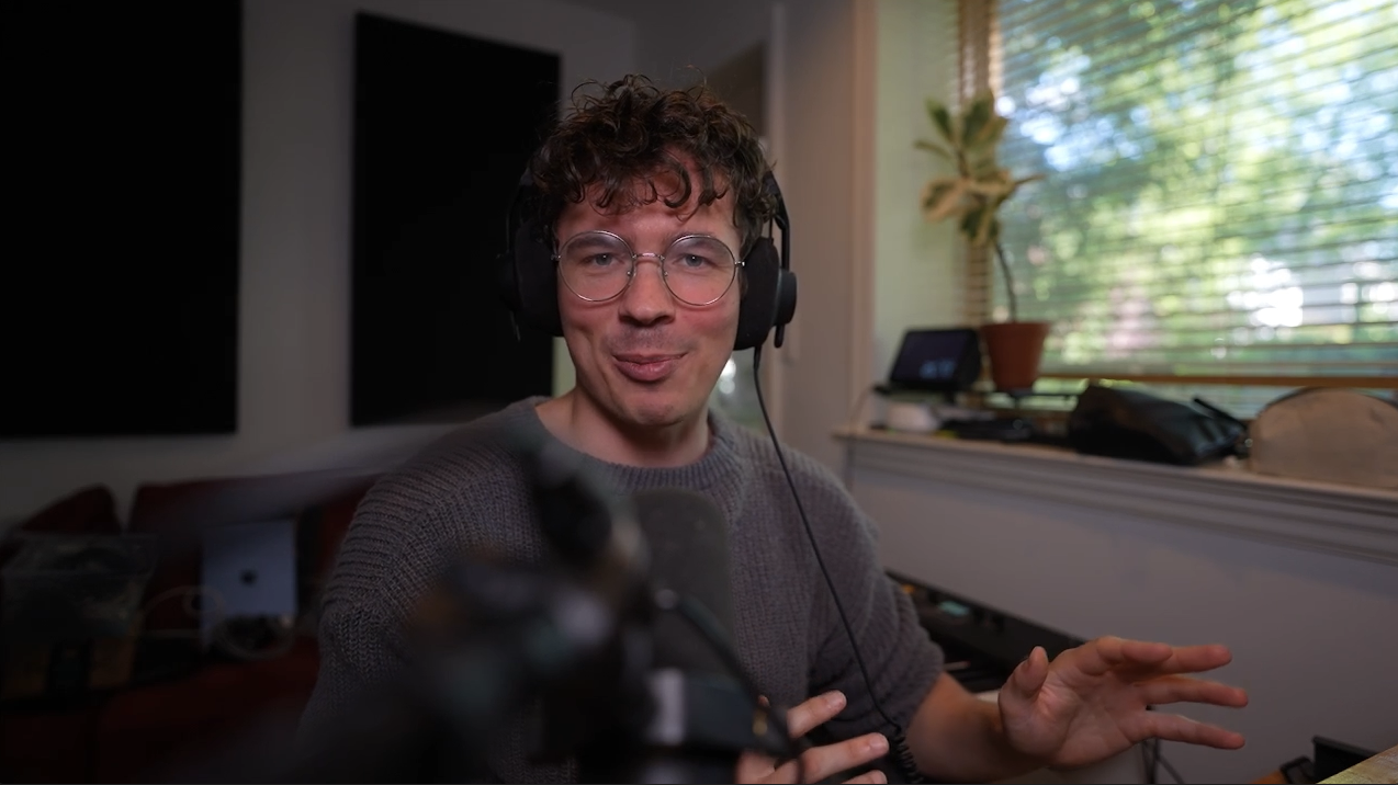Music teacher at Pike Music School, wearing headphones at a home production studio setup